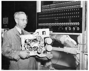 IBM ASCC-Mark I photo album: Edwin C. Kemble holding up Mark I interpolator